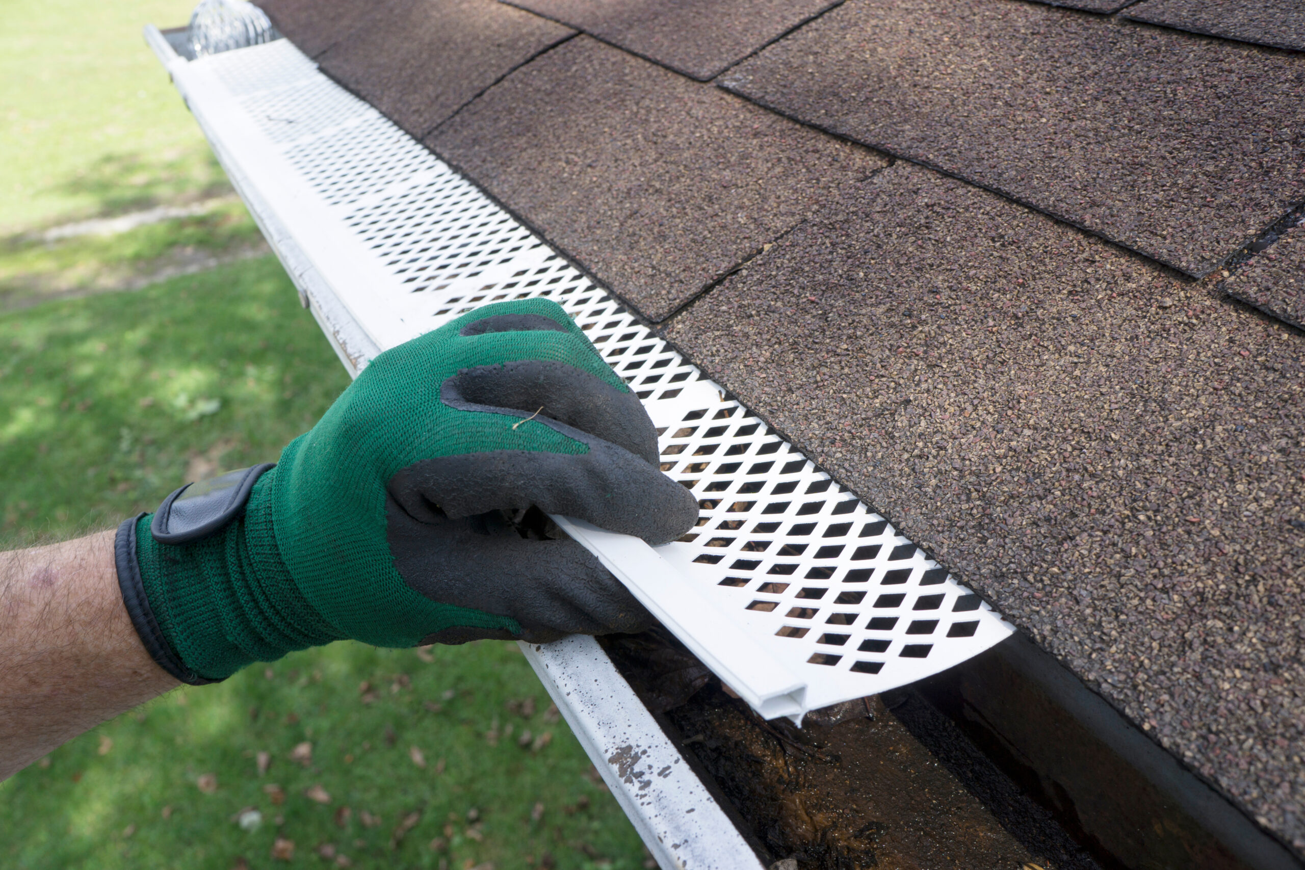 Contractor adjusting plastic gutter guards